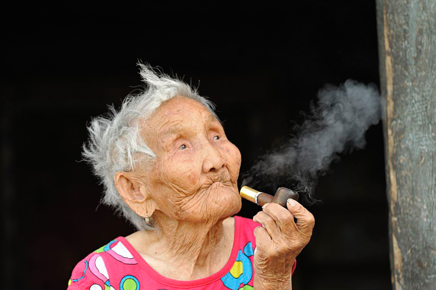 Старая женщина курит