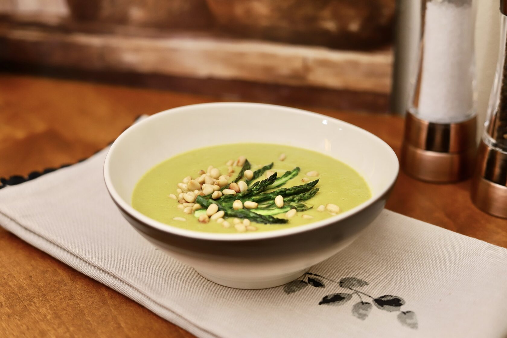 Asparagus Soup, flavored with lemon and garnished with pine nuts.