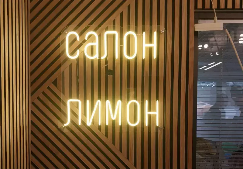 Белая неоновая надпись «Салон Лимон» на&nbsp;реечной стене