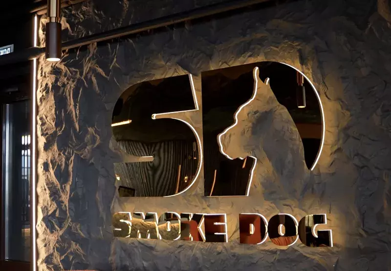 Логотип «Smoke Dog» с&nbsp;контражурной подсветкой на&nbsp;каменной стене