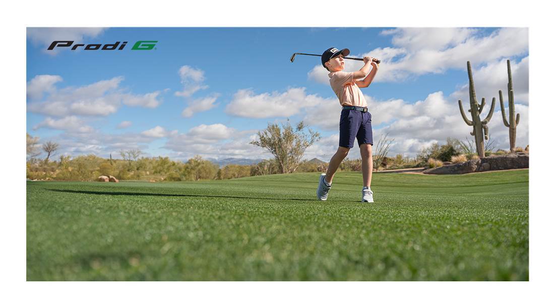 Мальчик гольфист играет в гольф