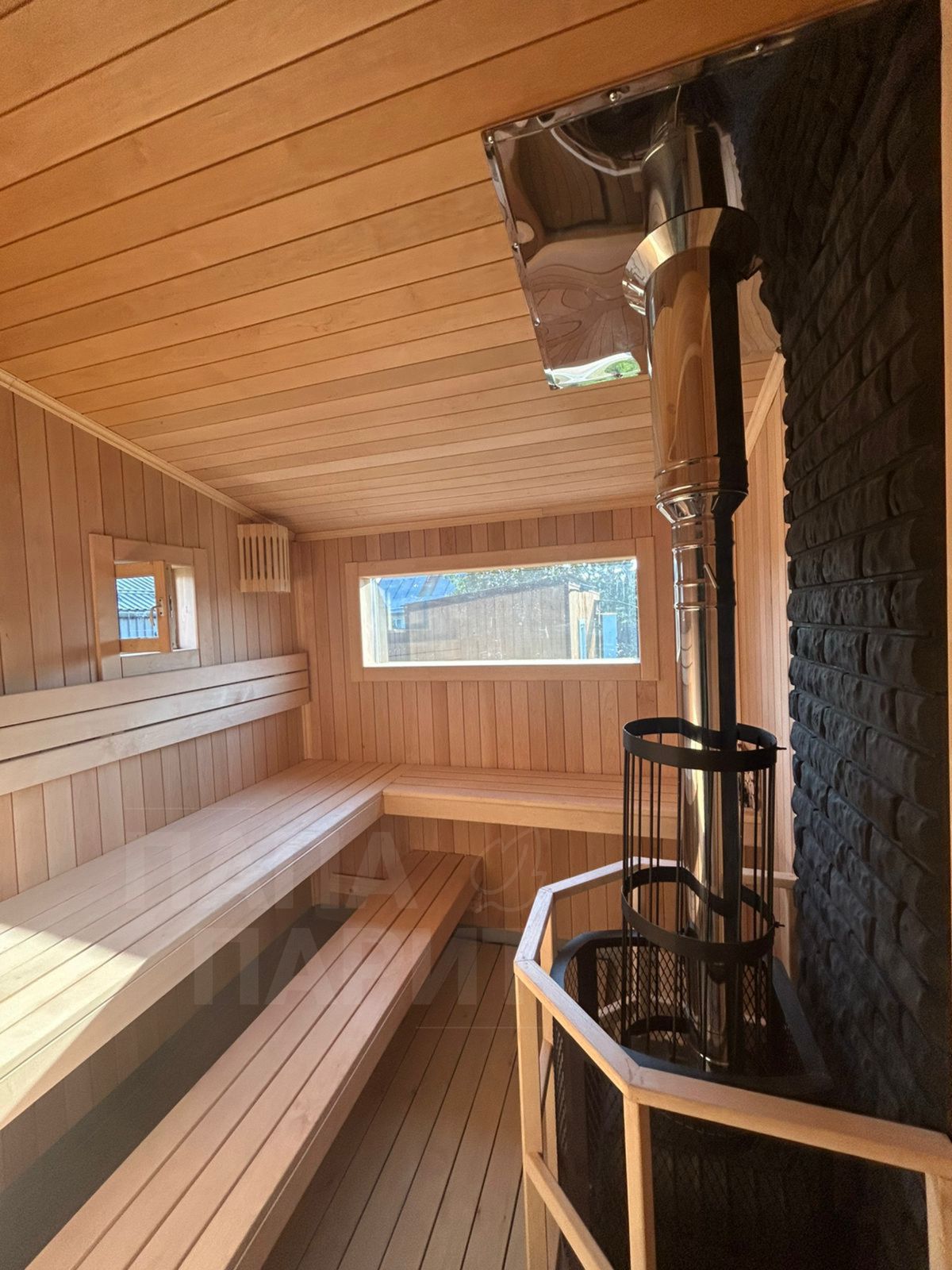 Парная бани Скандинавский House: полки, печь с сеткой для камней, окно
