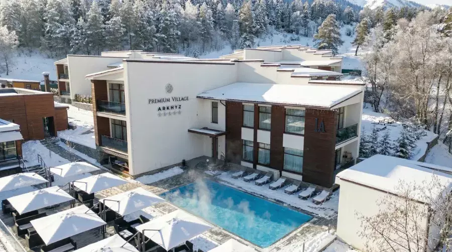 Корпус отеля Premium Village Arkhyz и бассейн зимой