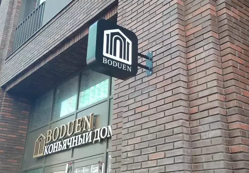 Кронштейн с&nbsp;логотипом коньячного дома «Boduen» на&nbsp;кирпичном фасаде