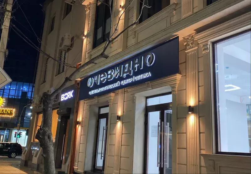 Вечерний фасад с&nbsp;подсвеченной вывеской «Очевидно»
