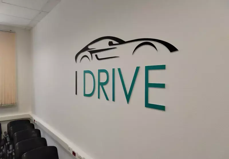 Логотип «I Drive» с&nbsp;автомобилем на&nbsp;стене офиса