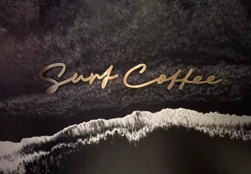 Золотая надпись «Surf Coffee» на&nbsp;тёмной стене