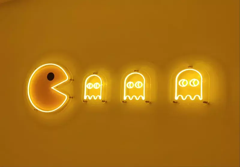 Жёлтые неоновые фигуры в&nbsp;стиле Pac-Man на&nbsp;жёлтой стене