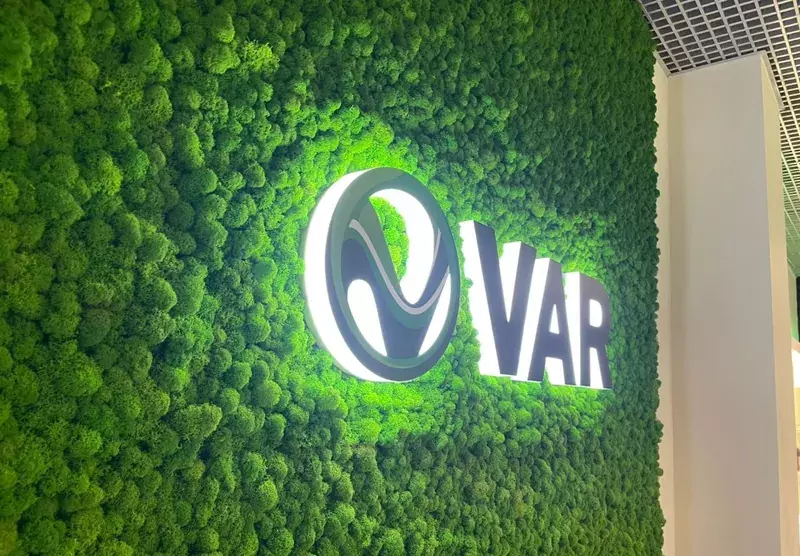 Световой логотип «VAR» на&nbsp;стене из&nbsp;мха