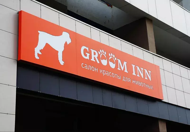 Оранжевый световой короб «Groom Inn» над входом в&nbsp;салон