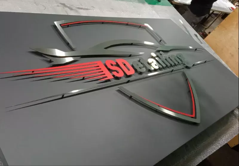 Логотип «SD detailing» из&nbsp;металла на&nbsp;тёмном фоне