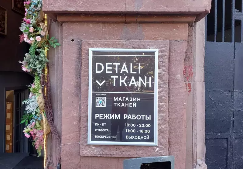 Табличка магазина «Detali Tkani» с&nbsp;режимом работы на&nbsp;фасаде