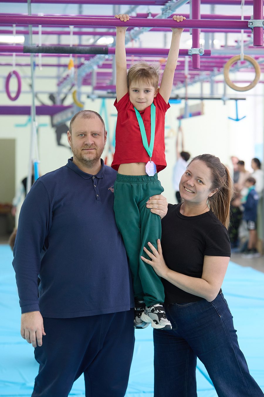 Мальчик с медалью и родителями
