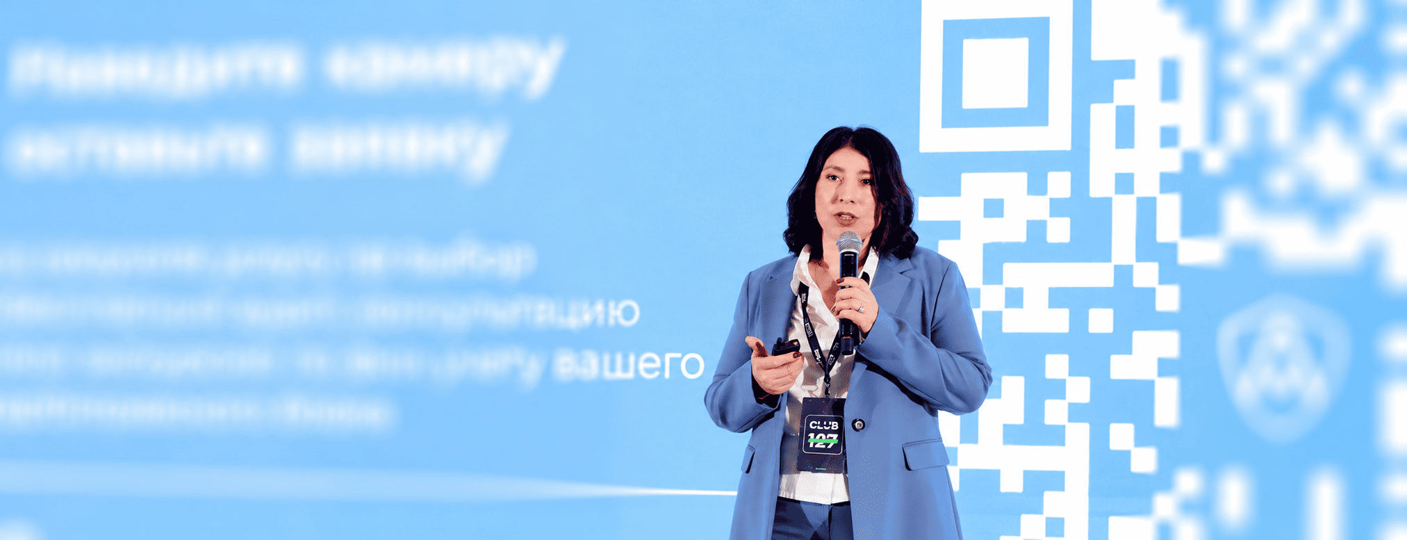 Ирина Агаева выступает на конференции с микрофоном
