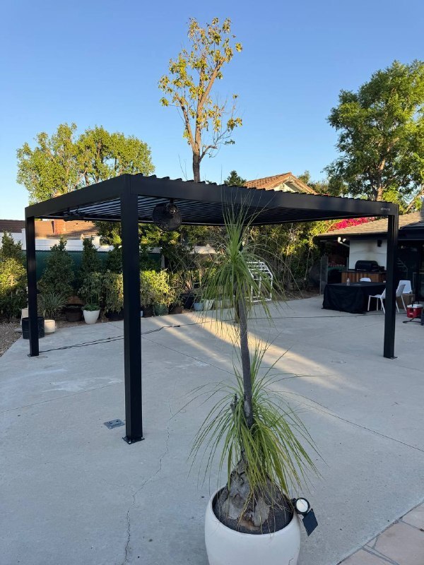 Completed dark gray aluminum pergola on poolside patio in Newport