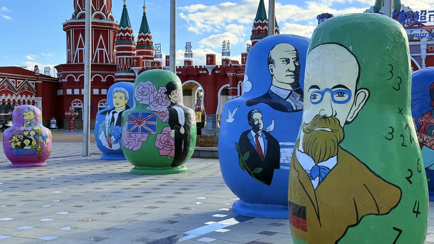 Расписные Матрёшки с портретами перед красными декоративными башнями