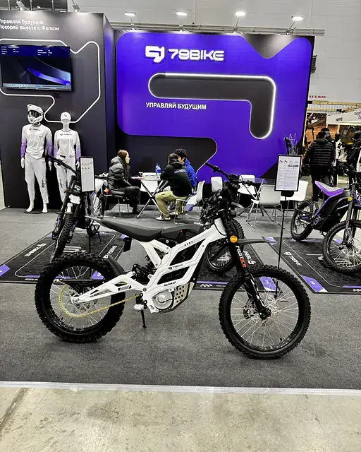 Стенд 79BIKE на выставке «Мотовесна 2026»: белый Falcon GT на фоне фирменной стены «Управляй будущим»