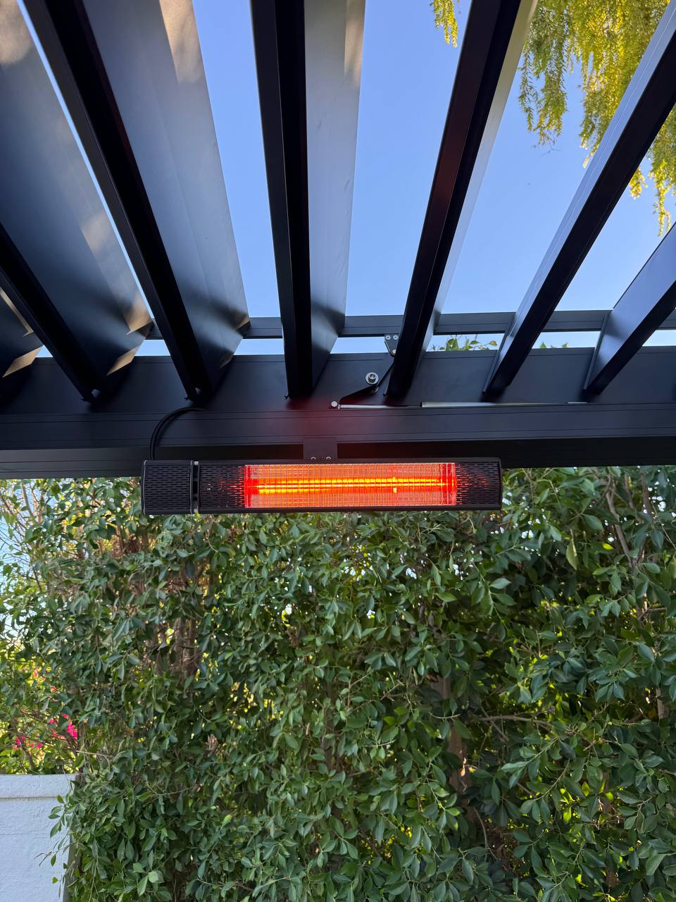 Close-up of operating infrared heater below adjustable louvers