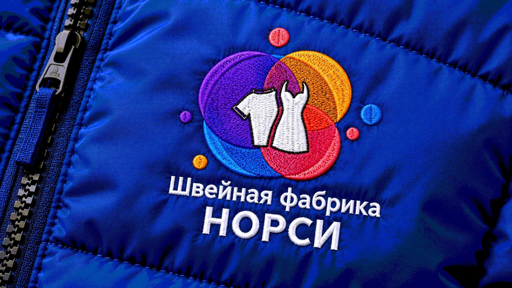 Машинная вышивка логотипа на зимней куртке в цехе швейной фабрики