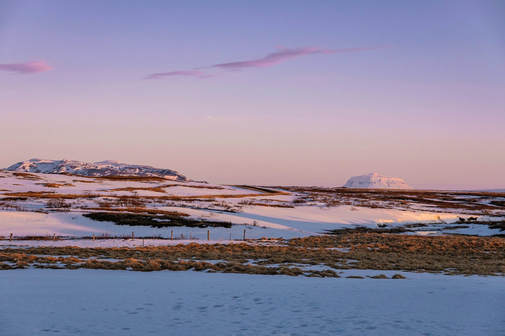 Frozen arctic mountains covered in snow under cold sky