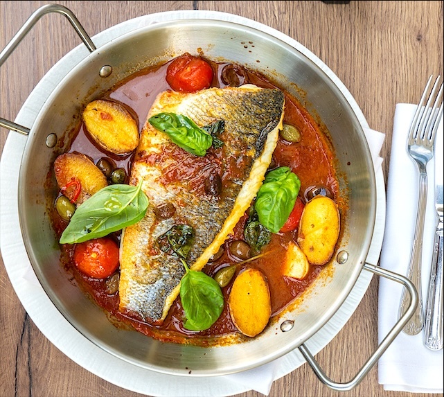 Сибас в сковороде с картофелем, оливками и томатами