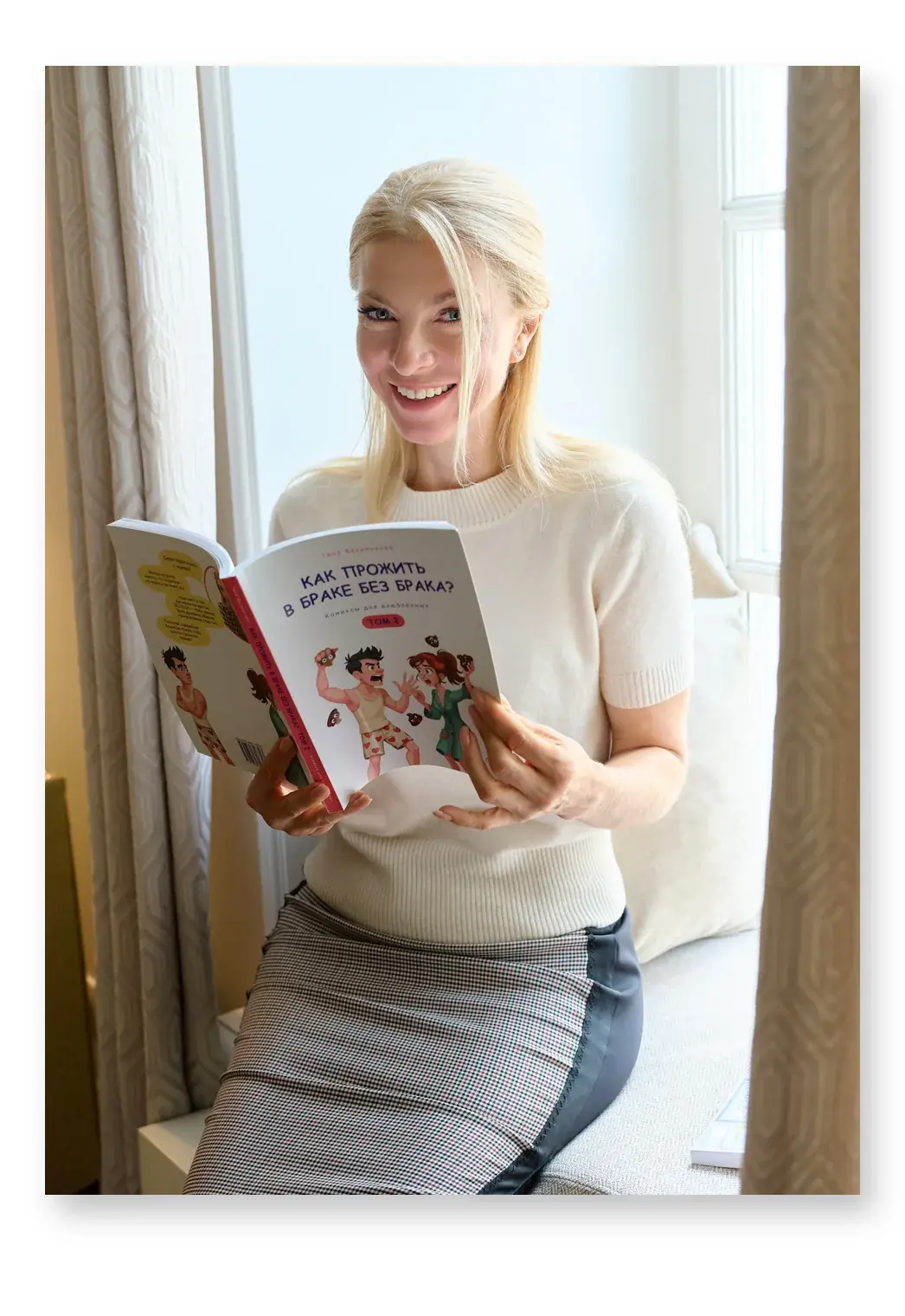 Таня Василькова с книгой-комиксом на подоконнике в кабинете