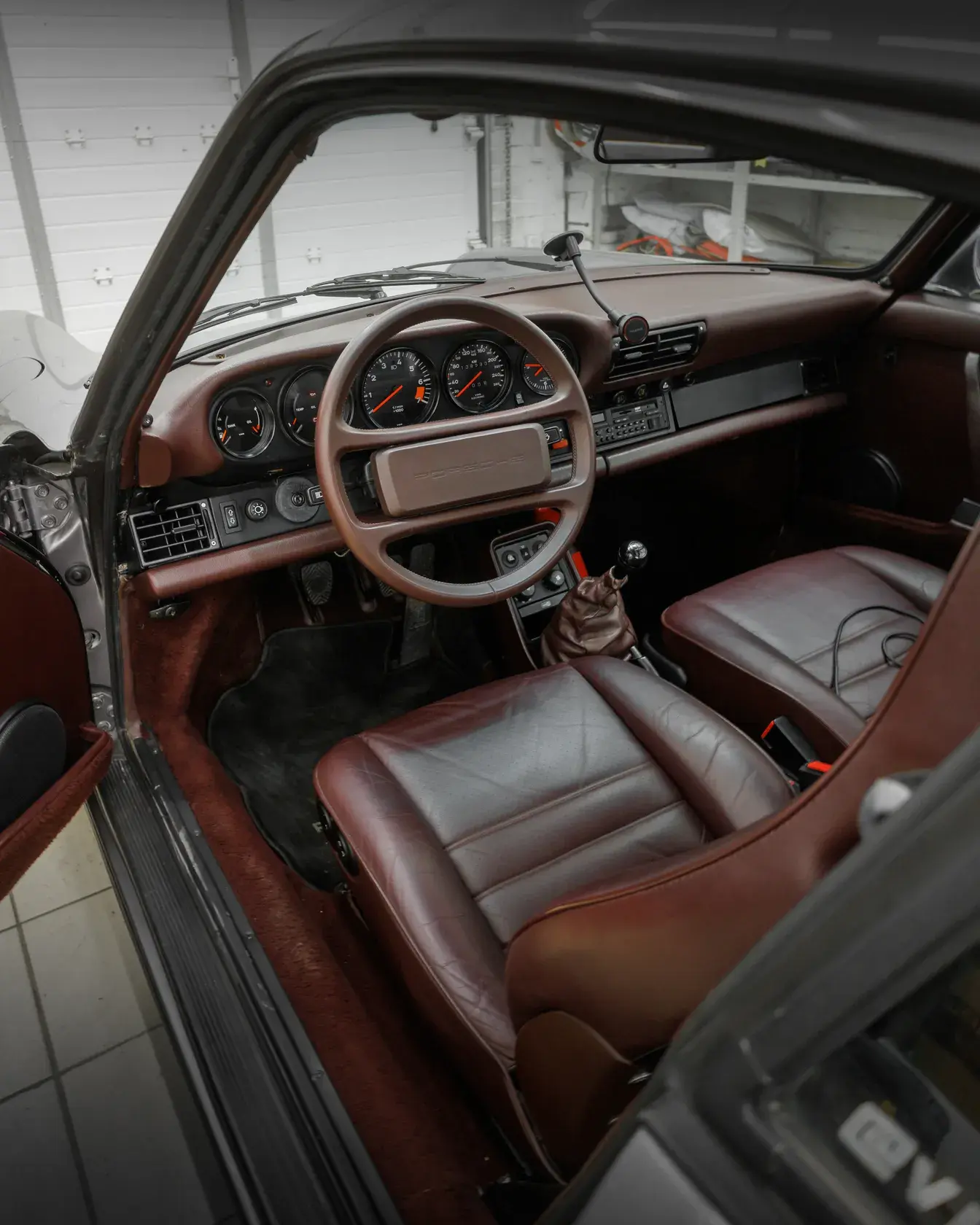 Салон Porsche 911 1986 в бордовой коже через открытую дверь