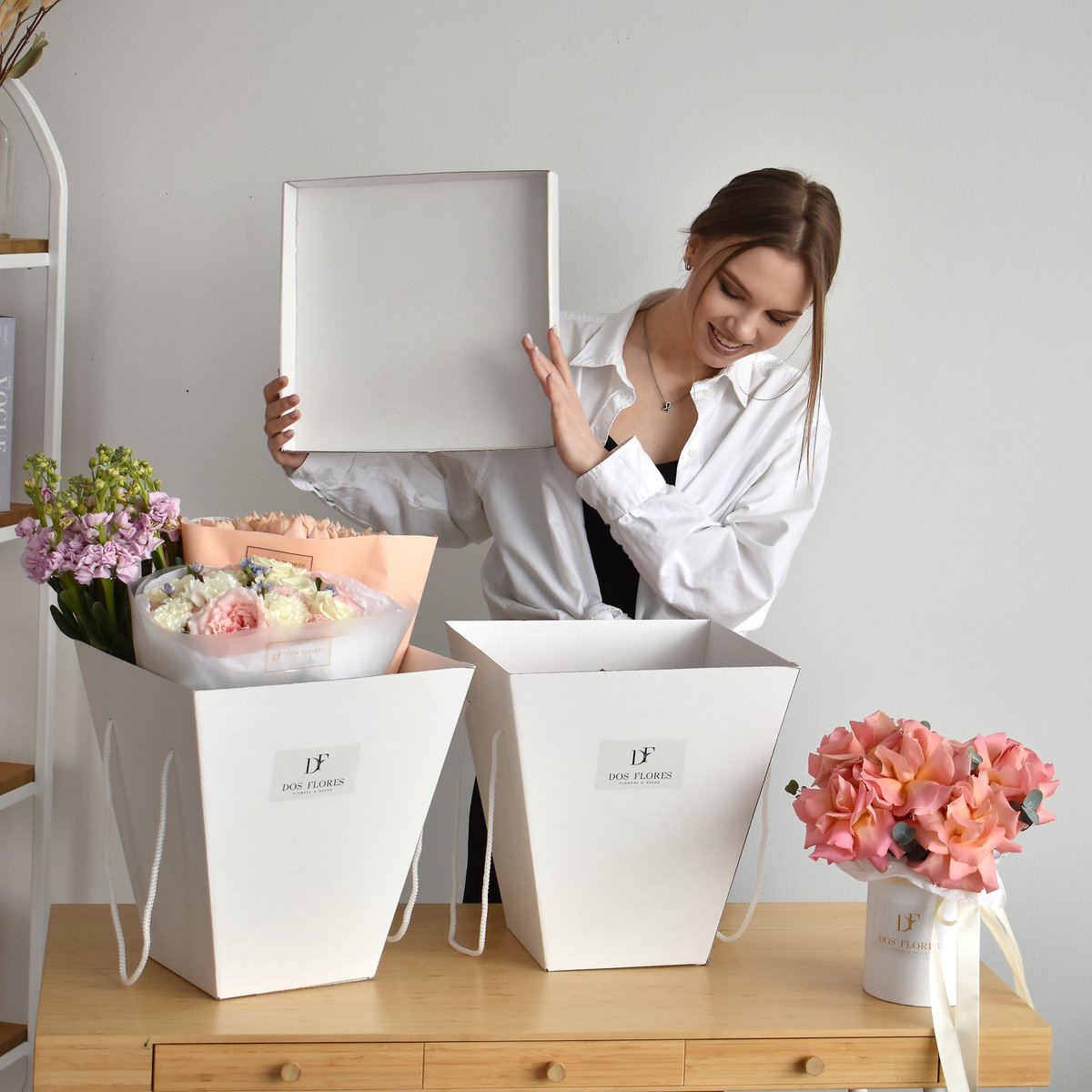 Флорист Dos Flores упаковывает свежие букеты в коробки-переноски