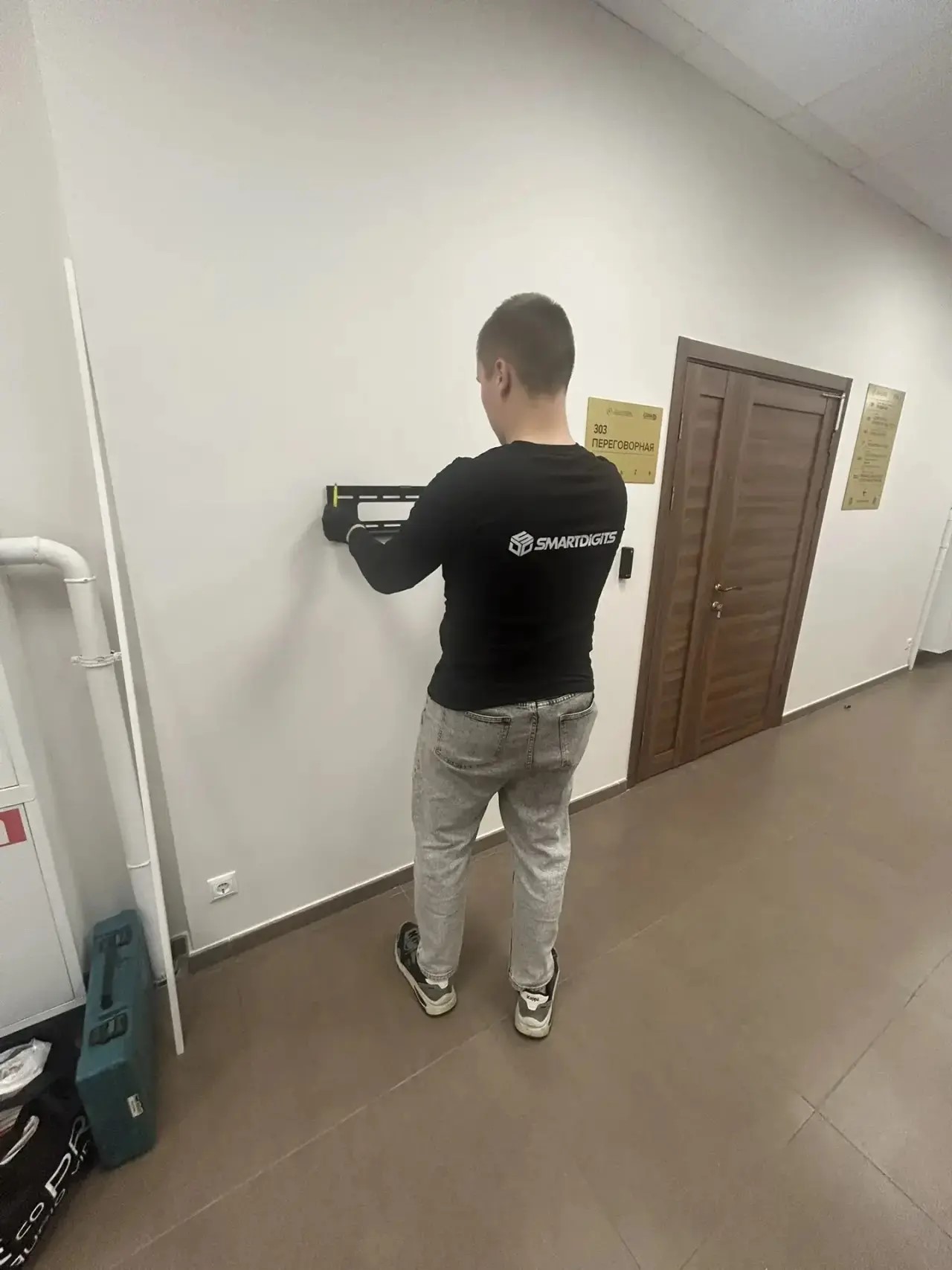 Специалист SMARTDiGiTS устанавливает настенное крепление дисплея