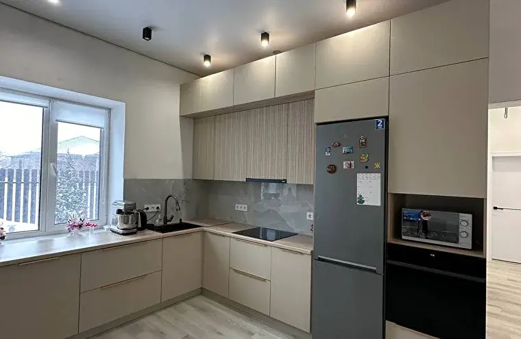 Светлая кухня с окном и встроенной техникой