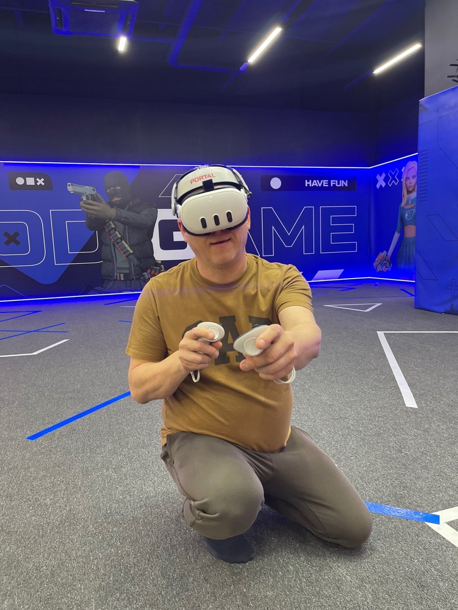 Взрослый участник с VR-шлемом и контроллерами на арене Portal VR