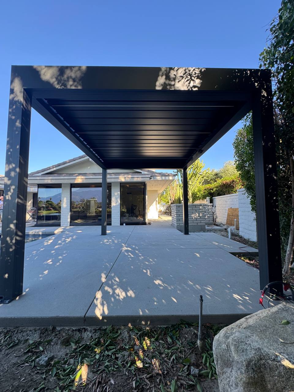 Freestanding pergola with louvers closed beside the Lake Forest home