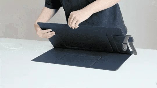 Руки меняют угол наклона подставки настольного коврика MOFT Smart Desk Mat