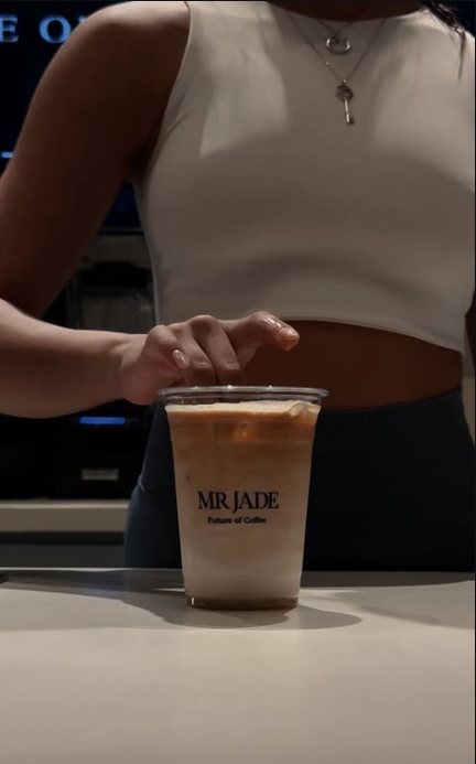 An iced latte in a MR JADE cup