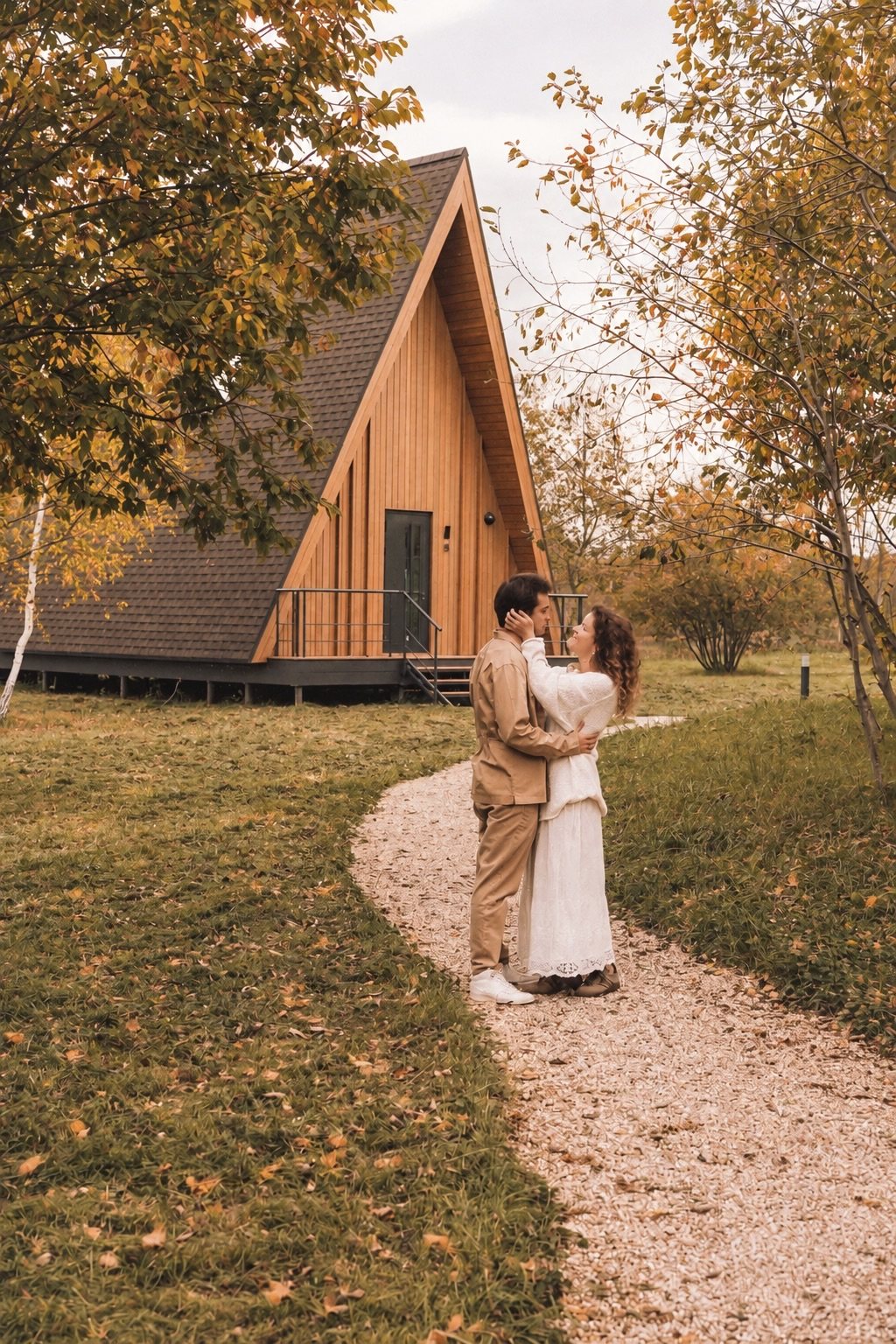 Пара на дорожке у A-frame дома осенью