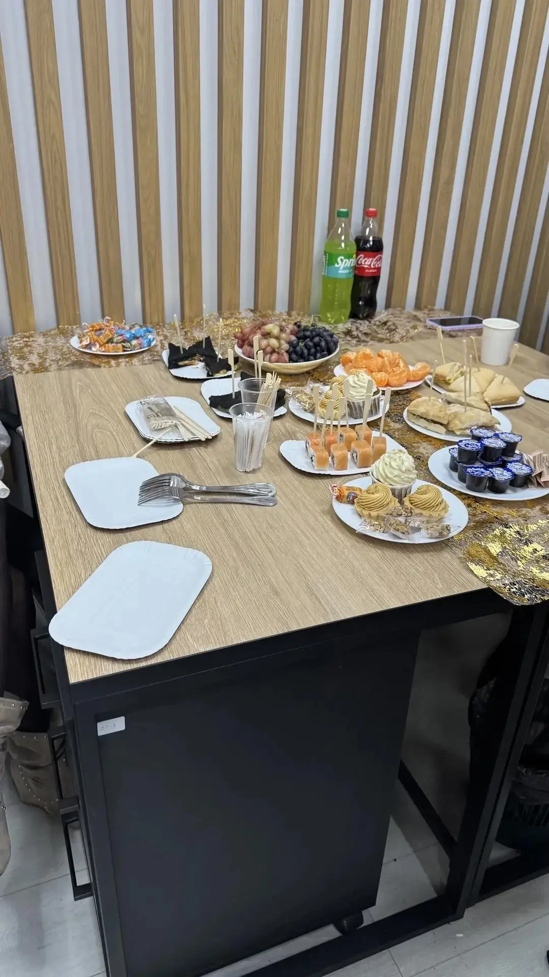 Угощения на столе перед рейками с логотипом компании