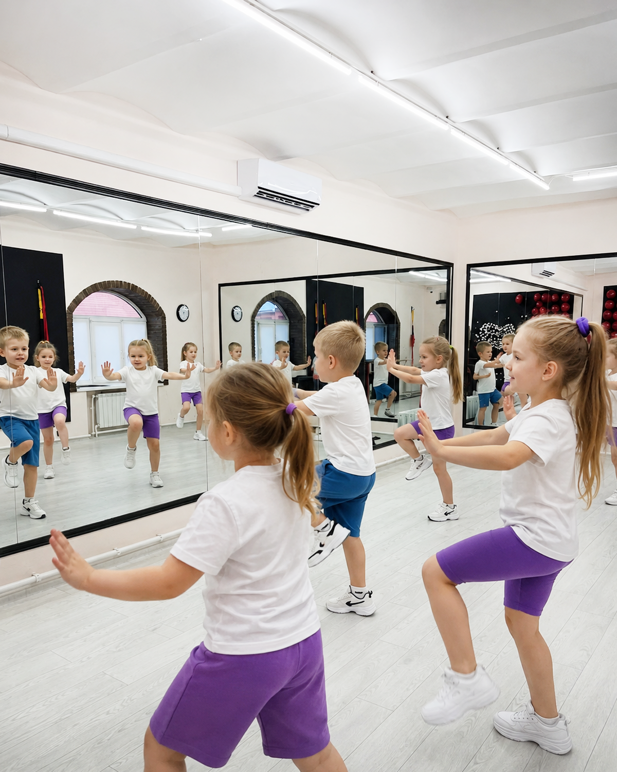 Дети 4–6 лет повторяют движения у зеркала на тренировке