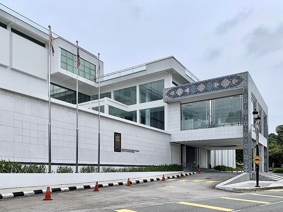 Белое здание Islamic Arts Museum Malaysia с орнаментальной полосой над входом