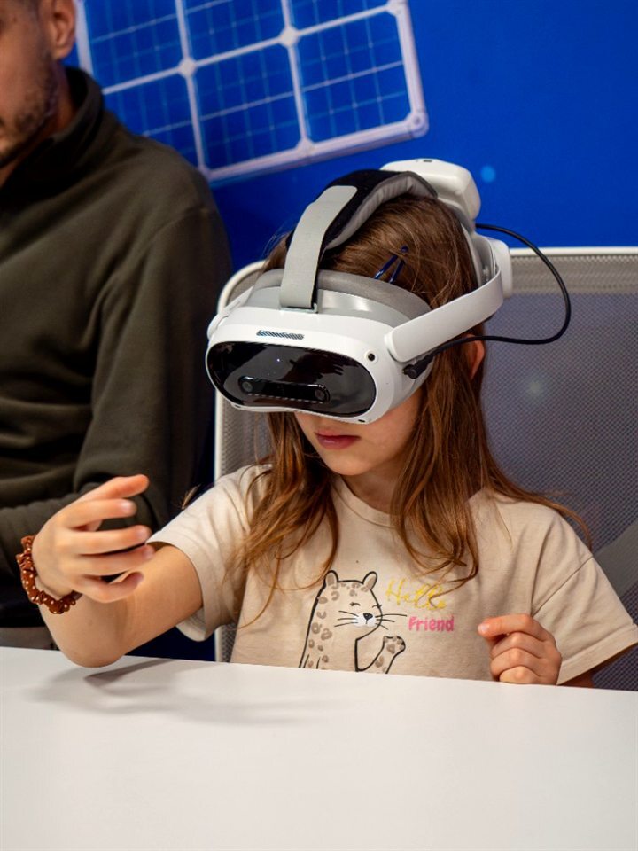 Девочка в VR-шлеме на уроке в классе