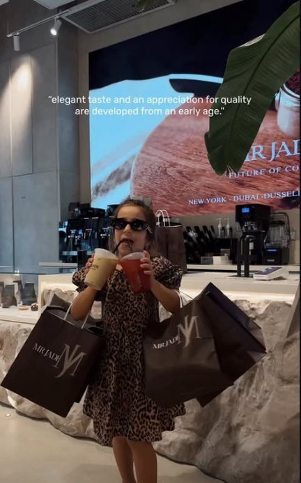 A little girl with MR JADE bags and two drinks at the counter