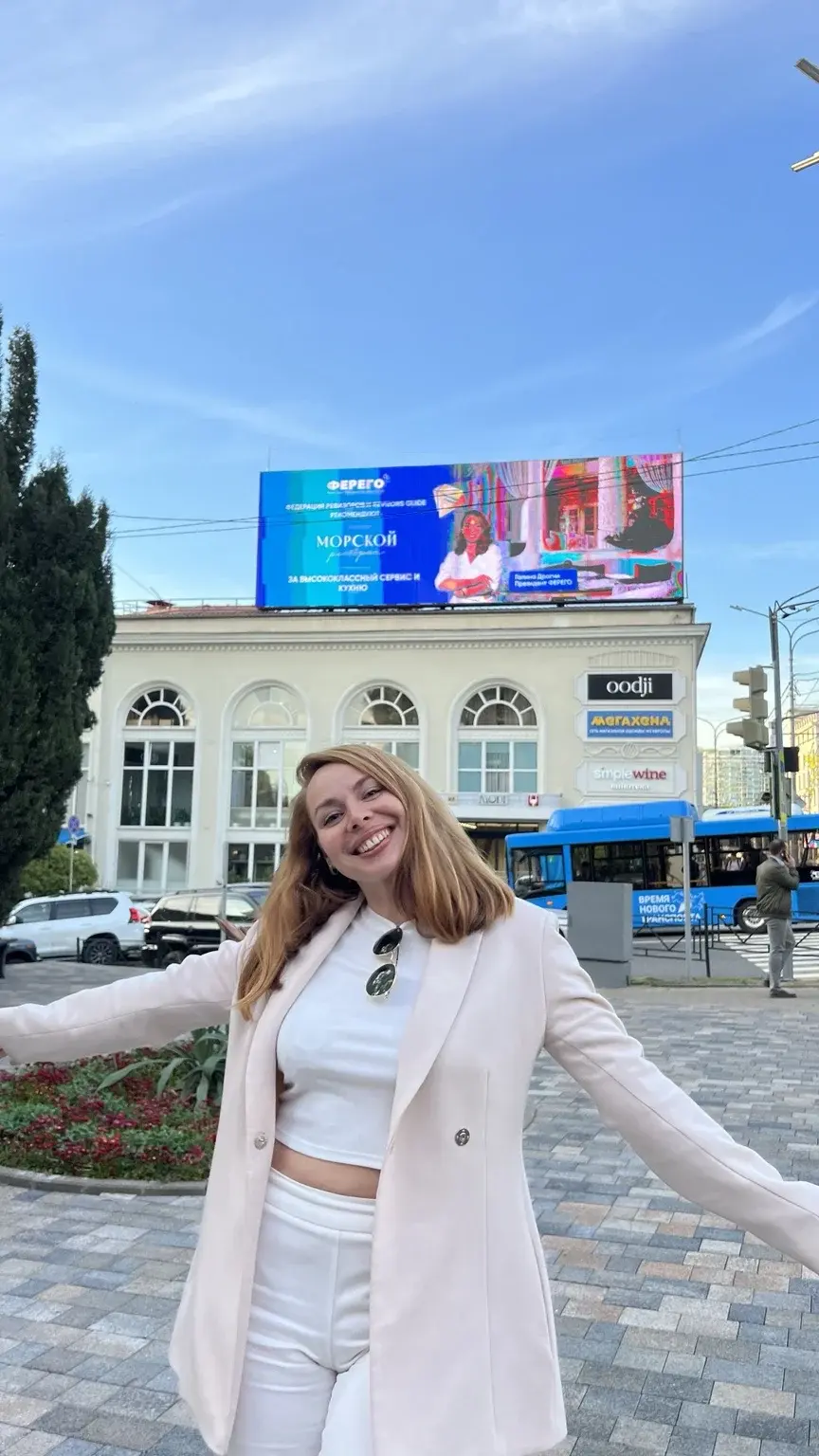 Галина перед рекламным экраном с её портретом