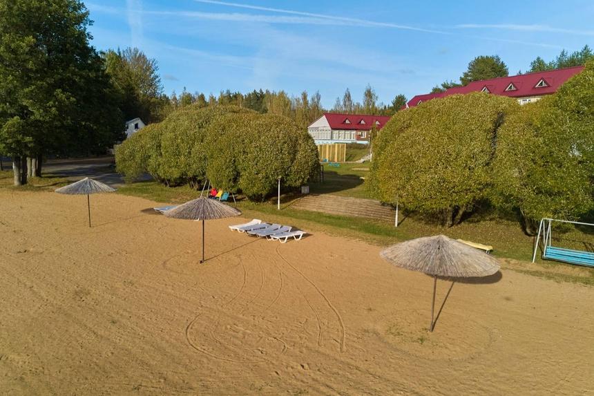 Пляж с зонтами и корпус на холме