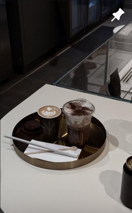 A flat white and an iced mocha on a gold tray
