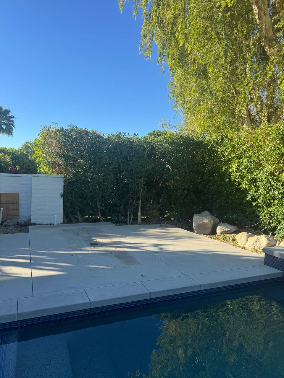 Existing poolside concrete patio before pergola installation in Lake Forest
