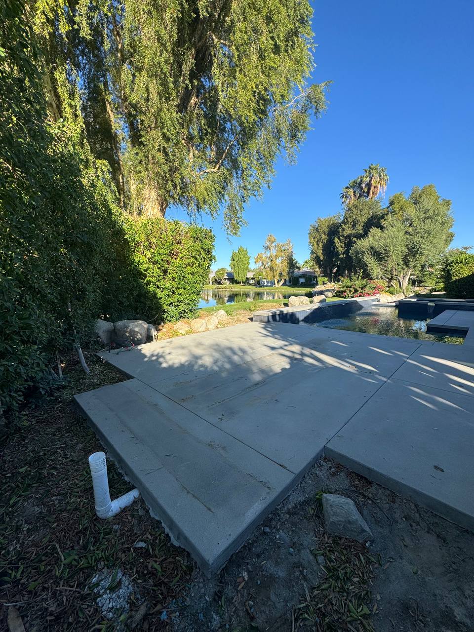 Concrete patio and pool area before pergola installation