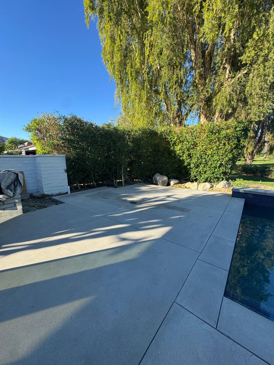 Poolside concrete slab before the freestanding pergola