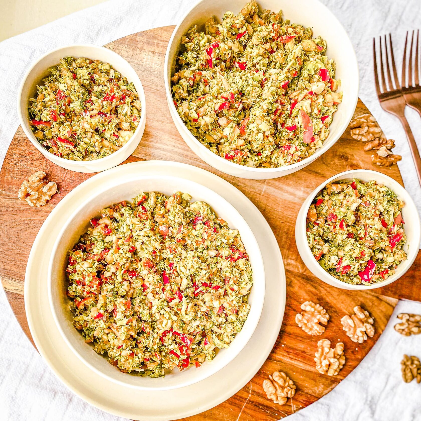 Vier Portionen Brokkoli-Salat in Schüsseln und Teller