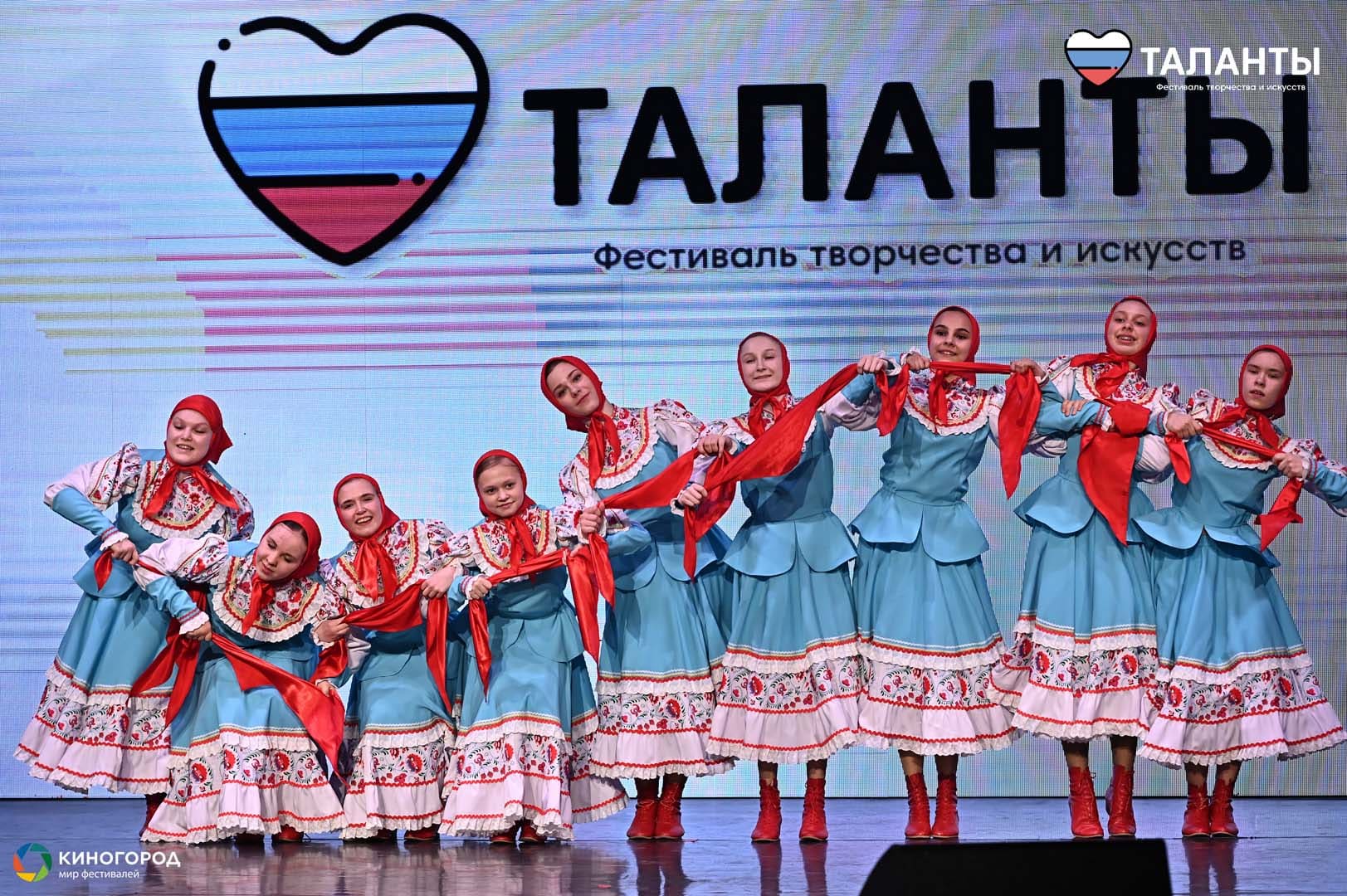 Танцевальный коллектив в голубых народных костюмах с красными платками на фестивале «Таланты»