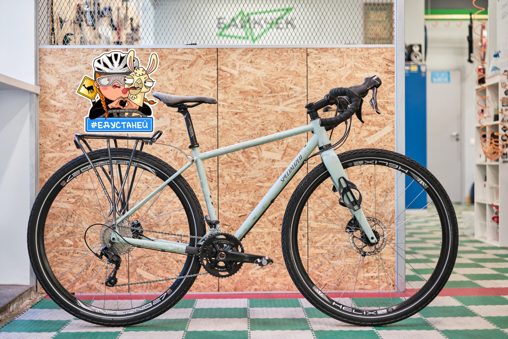 Светлый велосипед Specialized Sequoia с задним багажником в веломастерской