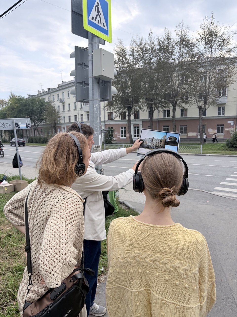 Участники прогулки сравнивают старую фотографию с улицей Сортировки